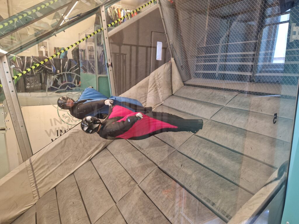 Two Havok Carve wingsuit flyers flying on their back in a wingsuit tunnel